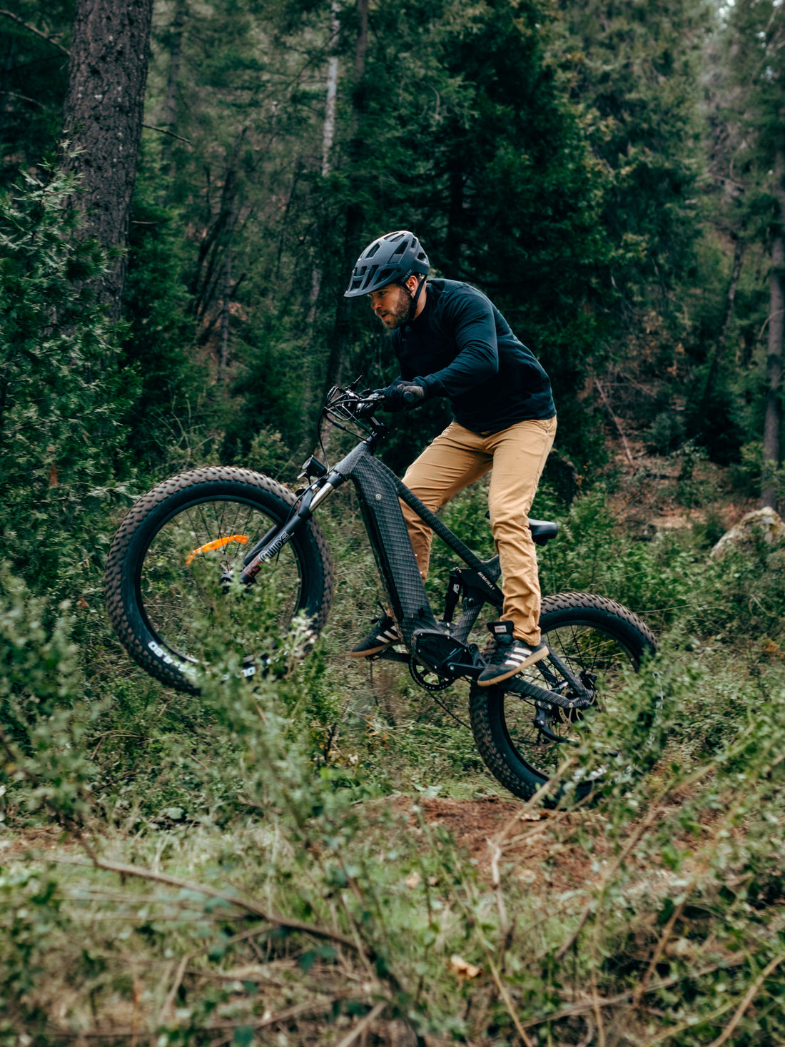 A full suspension electric mountain bike, Himiway Cobra, with black frame and orange details on the wheels and branding.